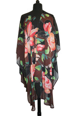 A hand painted silk georgette ruana with a floral pattern, displayed on a mannequin.